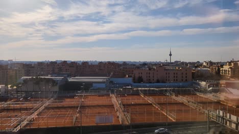 Luftaufnahme-Der-Skyline-Der-Stadt-Madrid-Am-Frühen-Morgen-Mit-Blauem-Himmel-Und-Tennisplatz-Im-Vordergrund