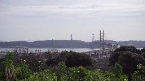 Time-lapse-Del-Puente-Colgante-Ponte-25-De-Abril-En-Lisboa-Con-Vegetación-En-Primer-Plano