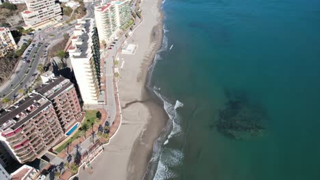 Aerial-lookdown-Fuengirola-sea-coast-bay-area,-zoom-in-on-sand-and-shore