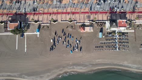 Aerial-drone-look-down-of-Fuengirola-coast-beach,-zoom-sailboats-at-shore