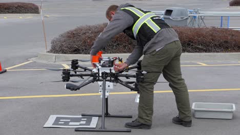 Un-Piloto-De-Drones-Quita-Las-Baterías-De-Un-Drone-De-Entrega-Y-Las-Coloca-En-Un-Contenedor,-A-Cámara-Lenta