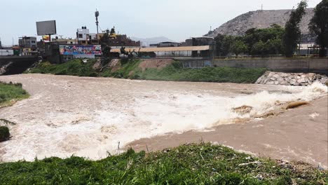 Murky-brown-water-flows-down-the-Rimac-River-in-Lima,-Perú-2023