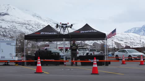 Piloto-De-Dron-Aterriza-Su-Dron-De-Entrega-En-Un-área-Marcada-De-Un-Estacionamiento-De-Walmart-En-Un-Día-Frío-De-Invierno-En-Utah,-Cámara-Lenta