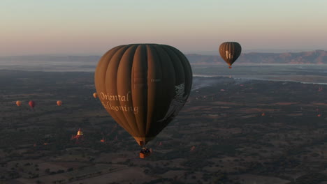 Beautiful-Aerial-Close-up-of-Hot-Air-Balloon-During-a-Sunrise-Over-Bagan,-Dhammayazika-Pagoda-Vissible-in-Background