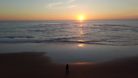 Atemberaubender-Sonnenuntergang-An-Der-Küste-Von-Cádiz,-Spanien,-Goldene-Stunde-Mit-Starkem-Sonnenstrahl,-Menschen,-Die-Den-Strand-Genießen