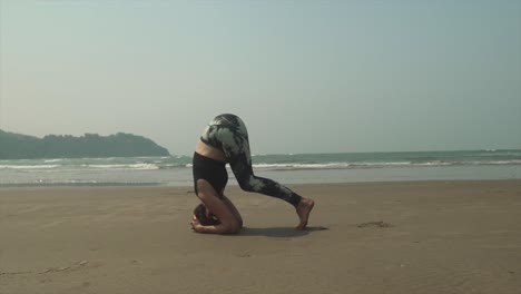 Frauen-Kontrollieren-Langsam-Ihre-Beine-Vom-Boden-Nach-Oben,-Während-Sie-Am-Strand-Yoga-Kopfstand-Machen