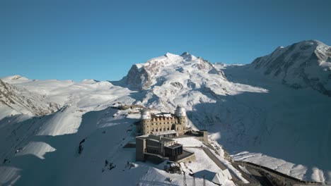 Drone-Circles-Above-Alpine-Mountain-Lookout,-Gornergrat.-Winter