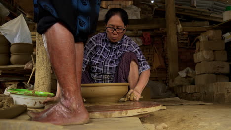 A-skilled-Asian-woman-finishes-a-clay-bowl-in-Thanh-Ha,-Vietnam,-showcasing-the-traditional-craft-of-pottery-and-the-beauty-of-local-tourism