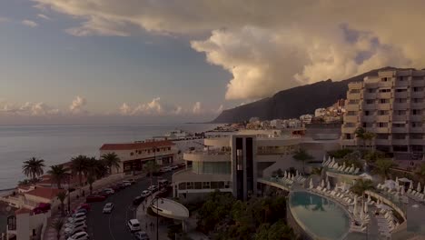 aerial-panoramic-view-of-fancy-coastline-in-tenerife-island-touristic-place-with-luxury-hotel-during-epic-warm-sunset-over-the-ocean-canary-island-spain