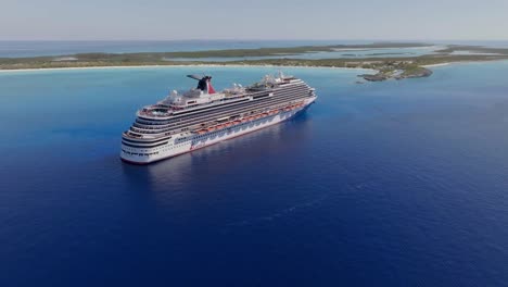 Vista-Aérea-Acercándose-Al-Crucero-Carnival-Dream-En-La-Costa-De-La-Pequeña-Isla-De-San-Salvador,-Bahamas