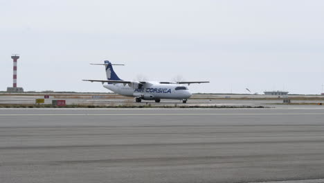 Blick-Vom-Flughafenterminal-Der-Air-Corsica-ATR-72-Turboprop-Flugzeuge,-Die-Nach-Der-Landung-Zum-Gate-Rollen