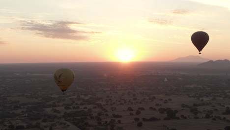 Hot-Air-Balloons-over-Bagan,-Myanmar-During-a-Cinematic-and-Dreamy-Sunrise,-Wide-Angle-Drone-Shot
