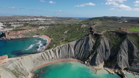 Bird's-Eye-View-Over-A-Tropical-Sandy-Beach-With-Clear-Turquoise-Water,-Qarraba-Bay,-Ghajn-Tuffieha-Bay-And-Clay-Cliffs,-Malta