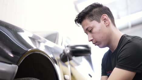 Slow-motion-shot-of-a-mechanic-removing-wheel-nuts-in-a-garage-on-a-Mercedes-Benz