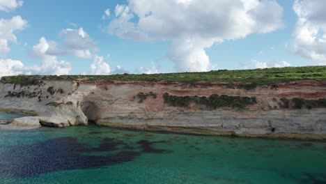 Munxar-Window-Drone-Footage,-Limestone-Cliff-Side,-Turquoise-Water,-Malta