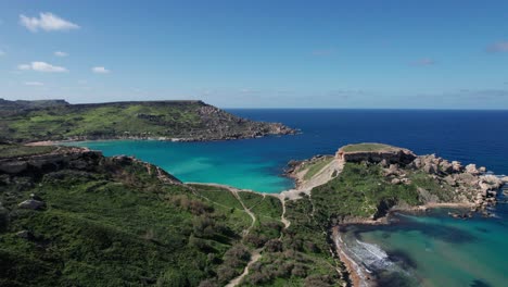 Drone-View-Over-A-Tropical-Sandy-Beach-With-Clear-Turquoise-Water,-Ghajn-Tuffieha-Bay,-Malta