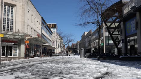 Eine-Haupteinkaufsstraße,-Die-Mit-Schnee-Und-Matsch-Bedeckt-Ist,-Während-Alles-Zu-Tauen-Beginnt