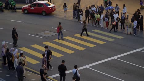 People-walk-across-one-of-the-busy-crosswalks-on-Kuala-Lumpur-street-in-Malaysia