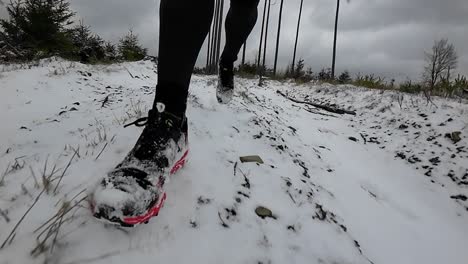 Close-up-front-view-slow-motion-of-a-trail-runner-on-steep-wintery-forest-downhill-trail