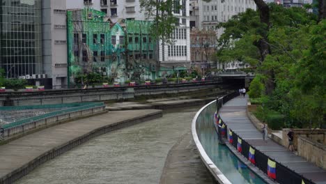 Blick-Auf-Den-Sanften-Fluss-Und-Die-Menschen,-Die-Auf-Der-Promenade-Entlang-Des-Klang-flusses-Im-Herzen-Von-Kuala-Lumpur-In-Malaysia-Spazieren-Gehen