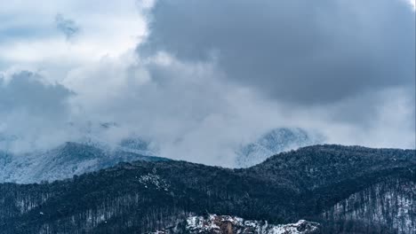 Timelapse-De-Montaña-De-Invierno-Con-Nubes-Blancas-En-Rápido-Movimiento-Que-Cubren-La-Ladera-De-La-Montaña,-Brasov,-Rumania
