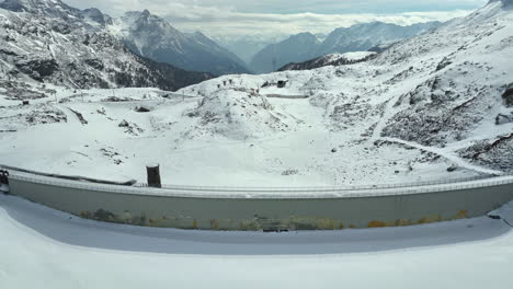 Rückwärts-Drohnen-Dolley-Aufnahme-Eines-Zugefrorenen-Sees-Am-Bernina-Staudamm-In-Der-Schweiz