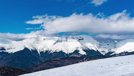 Wintergebirgszeitraffer-Mit-Sich-Schnell-Bewegenden-Wolken,-Gipfel-Bedeckt-Von-Einer-Dicken-Schicht-Weißen-Schnees,-Transalpina-Autobahn,-Rumänien