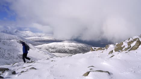 Excursionista-Masculino-Caminando-Sobre-El-Paisaje-Montañoso-De-Invierno-En-Escocia