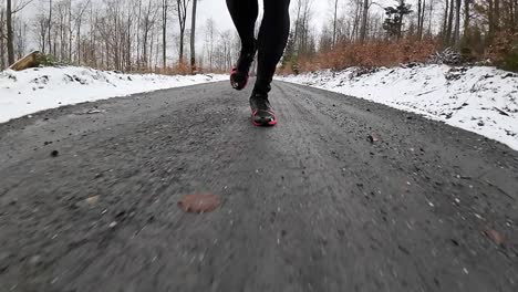 Close-up-front-view-slow-motion-of-a-trail-runner-on-wintery-forest-trails