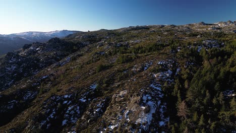 Aerial-pullback-from-Serra-da-Estrela-peak-during-winter-morning,-Snowy-landscape