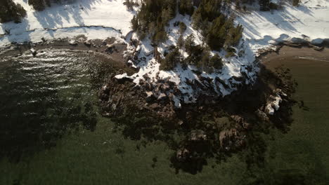 Drone-flight-over-the-ocean-in-winter-with-snow-in-Chandler,-Quebec,-Canada