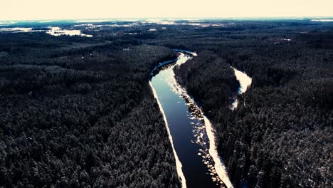 A-winding-river-near-a-small-town-with-a-forest-massif