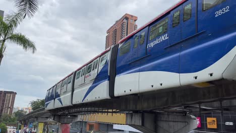 Monorraíl-Rápido-KL-Que-Sale-De-La-Estación-Bukit-Bintang-Con-El-Telón-De-Fondo-De-Berjaya-Times-Square-En-Kuala-Lumpur,-Malasia