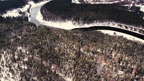 Un-Río-Sinuoso-Cerca-De-Un-Pequeño-Pueblo-Con-Un-Macizo-Forestal