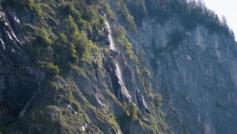 Beautiful-waterfall-at-Koenigssee-flows-down-a-steep-cliff