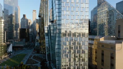 Ascending-aerial-view-of-traffic-and-a-mirroring-One-Waterline-Square-building-in-Riverside-Boulevard,-NY,-USA