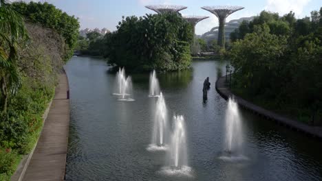 Laid-back-views-of-the-water-fountain-against-the-Flower-Dome-and-Super-Trees-in-Gardens-By-the-Bay,-Singapore