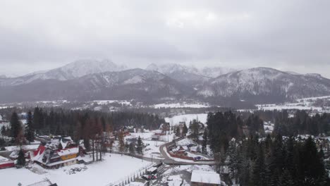 Drone-trucking-shot-of-the-wintersport-village-Zakopane-during-a-snow-shower