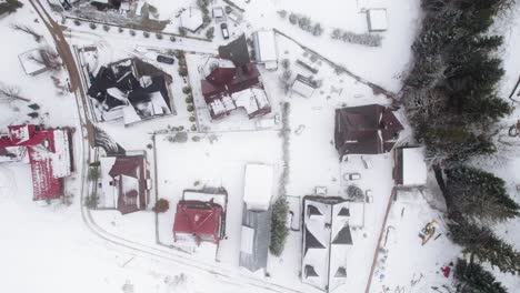 Top-down-drone-lifting-shot-of-snow-falling-down-in-Zakopane-in-winter-time