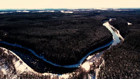 A-winding-river-near-a-small-town-with-a-forest-massif