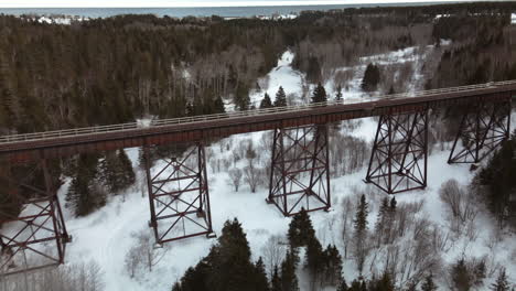 Drohnenflug-über-Eine-Eisenbahnbrücke-Im-Winter-Mit-Schnee-Auf-Dem-Boden