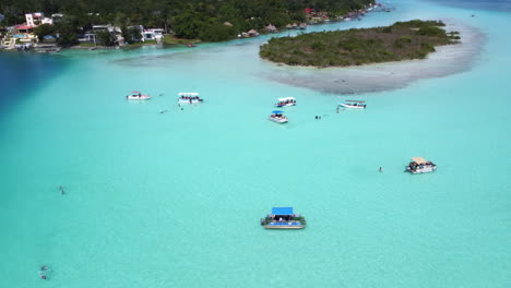 Drone-clip-of-the-7-color-lagoon-in-Bacalar-Mexico-in-4K---Beautiful-Aerial-View-Of-boats-in-shallow-Turquoise-Blue-Waters