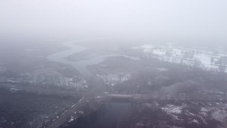 Drone-flying-down-out-of-the-clouds-in-Sudbury,-Massachusetts