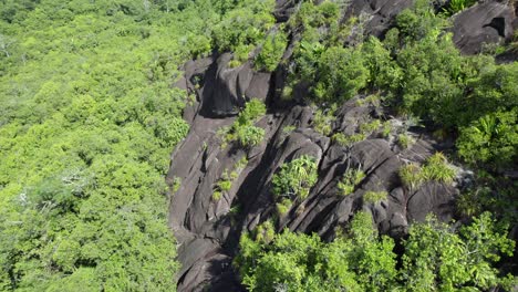 Drone-reveal-shot-near-granite-rock-of-Seychelles-highest-mountain,-Morn-Seychellois