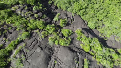 Drone-upward-shot-from-huge-granite-rock-in-the-lush-forest-on-Mahe-Island-Seychelles