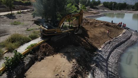 Excavator-dredging-soil-in-city-park-construction-site,-mexico