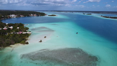 Aerial-shot-overseeing-the-white-sand-beaches-and-the-town-of-Bacalar,-Mexico