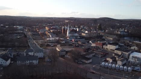 Drone-approaching-the-center-of-the-town-in-Hudson,-Massachusetts-during-winter