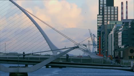 Stadtbild-Von-Menschen,-Die-Auf-Einer-Brücke-In-Dublin-Gehen,-Stativ-Zur-Goldenen-Stunde
