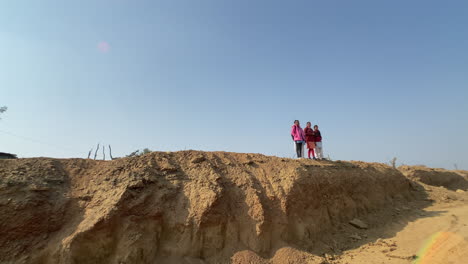 Low-angle-shot-of-school-girls-standing-on-a-coal-mountain